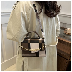 Detail of color-block plaid crossbody bag with gold chain and matching shoulder strap