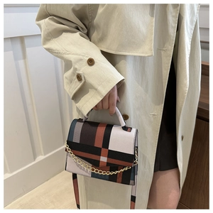 Detail of multi-color geometric plaid pattern and gold chain on the crossbody bag