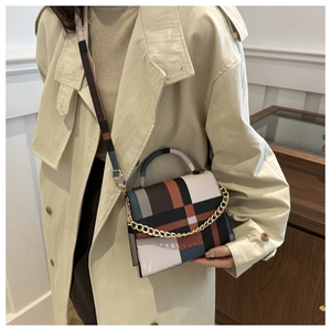 Close-up of geometric color-block shoulder bag with gold chain and matching printed strap