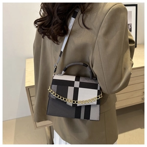 Detail of color-block plaid crossbody bag with golden chain and adjustable strap