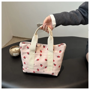 Pink corduroy strawberry print tote bag with cream handles in a minimalist style