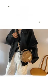 Détail du sac bandoulière rond kaki avec étiquette mode et coutures décoratives
