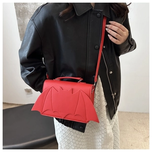 Détail du sac bandoulière chauve-souris rouge avec rabat ailé sur veste en cuir noir