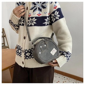 Détail du sac rond gris style denim avec poche tendance et rivets métalliques argentés