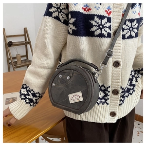 Détail d'un sac rond en patchwork de denim avec design poche jean et clous métalliques
