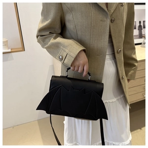 Sac à main noir en forme de chauve-souris avec ailes et poignée ronde sur mannequin