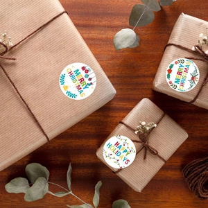 Round Merry Christmas stickers on kraft gift box with festive decorative elements