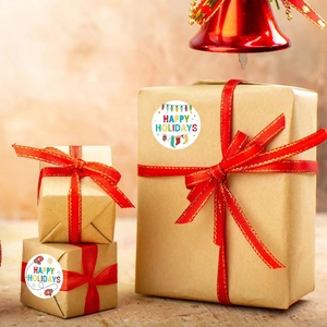 Round Happy Holidays stickers with Christmas lights on brown kraft gift box with red ribbon