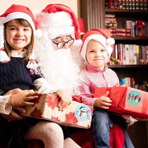 Christmas round gift stickers with Santa and penguin designs on festive boxes