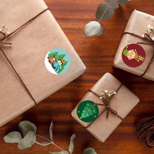 Festive round Christmas stickers with Santa, penguin and tree icons on gift boxes