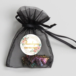 Black mesh drawstring pouch with a rainbow bismuth crystal and Thank You sticker