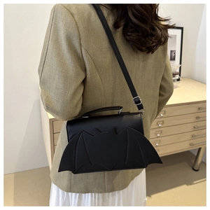 Détail d'un sac bandoulière en cuir forme chauve-souris avec ailes et sangle réglable