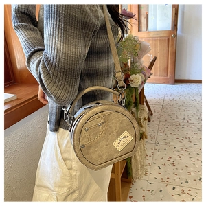 Détail du sac rond en denim patchwork avec poches vintage et rivets métalliques