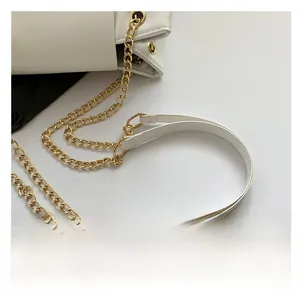 Detail view showing the dual strap design with gold chain and leather on white shoulder bag