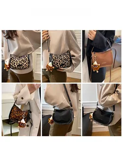 Detail showing vintage matte crossbody bags with lion plush pendant and adjustable strap