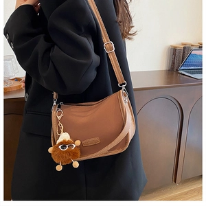 Brown nylon hobo bag shown in a professional lifestyle setting on a model