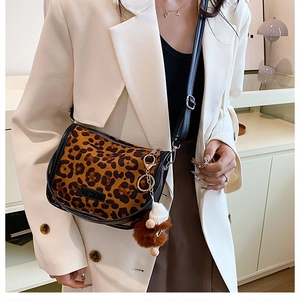 Detail of leopard print crossbody bag with faux fur texture and black leather trim accents