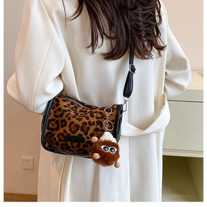 Detail showing vintage leopard print crossbody bag with furry monster charm and strap