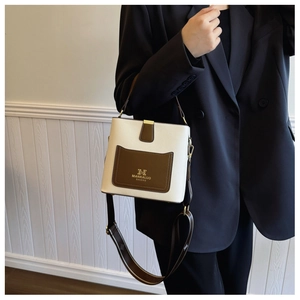 Detail of contrast bucket bag with litchi grain texture and adjustable shoulder strap