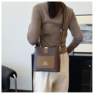 Detailed view of large-capacity bucket bag with wide strap worn on female model back