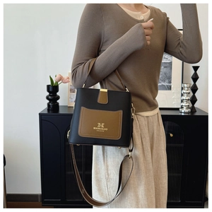 Detailed view of luxury bucket bag featuring荔枝纹 leather and golden hardware accents