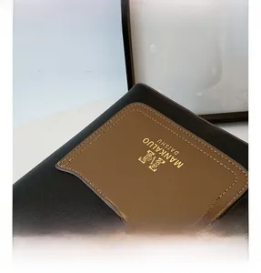 Detail of the litchi grain black and brown leather texture with gold logo branding