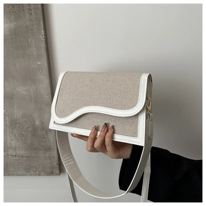 Detail of the wave-curved flap and contrast beige canvas with white leather stitching
