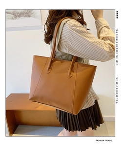 Detail einer großen braunen Kunstleder-Tote-Bag mit langen Henkeln in minimalistischem Stil