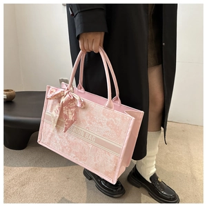 Detailed close-up of pink jacquard tote bag with floral embroidery and silk scarf handle