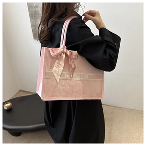 Detail der rosa Jacquard-Tragetasche mit Blumenmuster, Modetext und einem Seidenschal