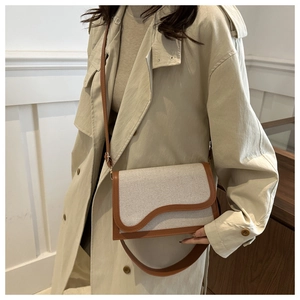Elegant canvas and PU leather shoulder bag with wavy flap design on a model