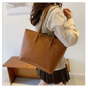Braune Leder-Tragetasche am Modell mit geräumigem Design für den täglichen Arbeitsweg