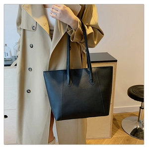 Detailansicht der minimalistischen schwarzen Leder-Einkaufstasche getragen von einem Model