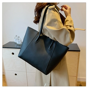 Detail einer großen schwarzen Shopper-Tasche mit feiner Lederstruktur und Nähten
