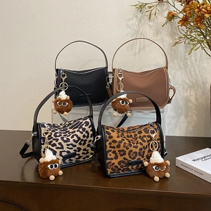 Retro leopard print pillow bag in four colors with plush ball charm on display