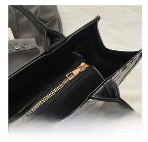 Nahaufnahme des glatten goldfarbenen Metallreißverschlusses der schwarzen Leder-Tote-Bag