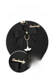 Detail of black lychee grain leather handbag with gold Danbaoly logo and bow decor