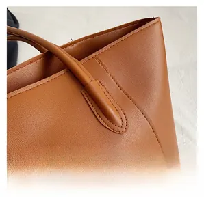 Detailaufnahme der verstärkten Nähte an einer karamellbraunen Totebag aus Leder mit Narbung