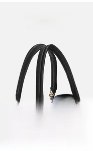 Close-up of durable golden metal hardware and premium black lychee leather on handbag