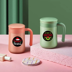 Christmas themed adhesive labels on pink and green mugs with handle and lid decorations