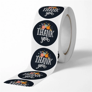 Close-up of a roll of black floral thank you stickers for gift sealing and packaging