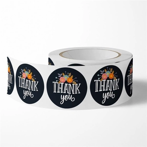 Macro shot of a roll of black round thank you stickers with colorful floral illustrations