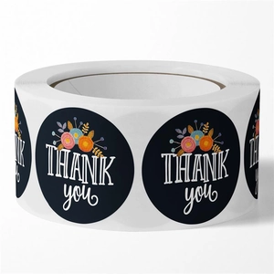 Detailed view of floral Thank You stickers on a roll with dark blue background and blossoms