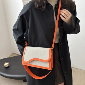 Contrast color crossbody bag with cream canvas and orange scalloped leather trim details