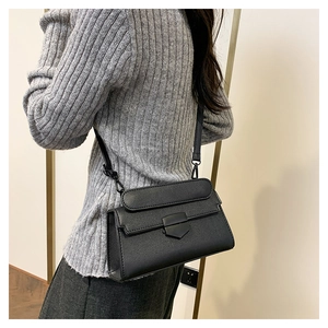 Detail of a vintage black stone-pattern crossbody bag worn on shoulder by a model