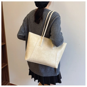 Detailed side view of a large cream tote bag with soft texture for daily commuting