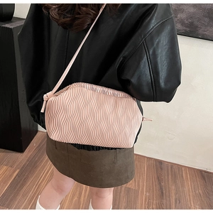 Detail der rosa plissierten Wolken-Tasche mit dünnem Riemen auf einer Lederjacke
