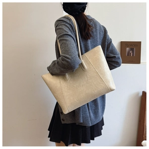Detail view of large cream tote bag with textured vintage leather and twin shoulder straps