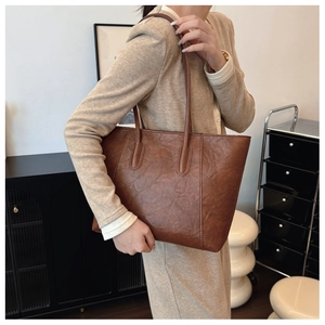 Brown vintage faux leather tote bag showing the textured surface and long shoulder straps