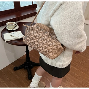 Detail der beige plissierten Cloud Bag mit feiner Faltenstruktur und schmalem Schulterriemen